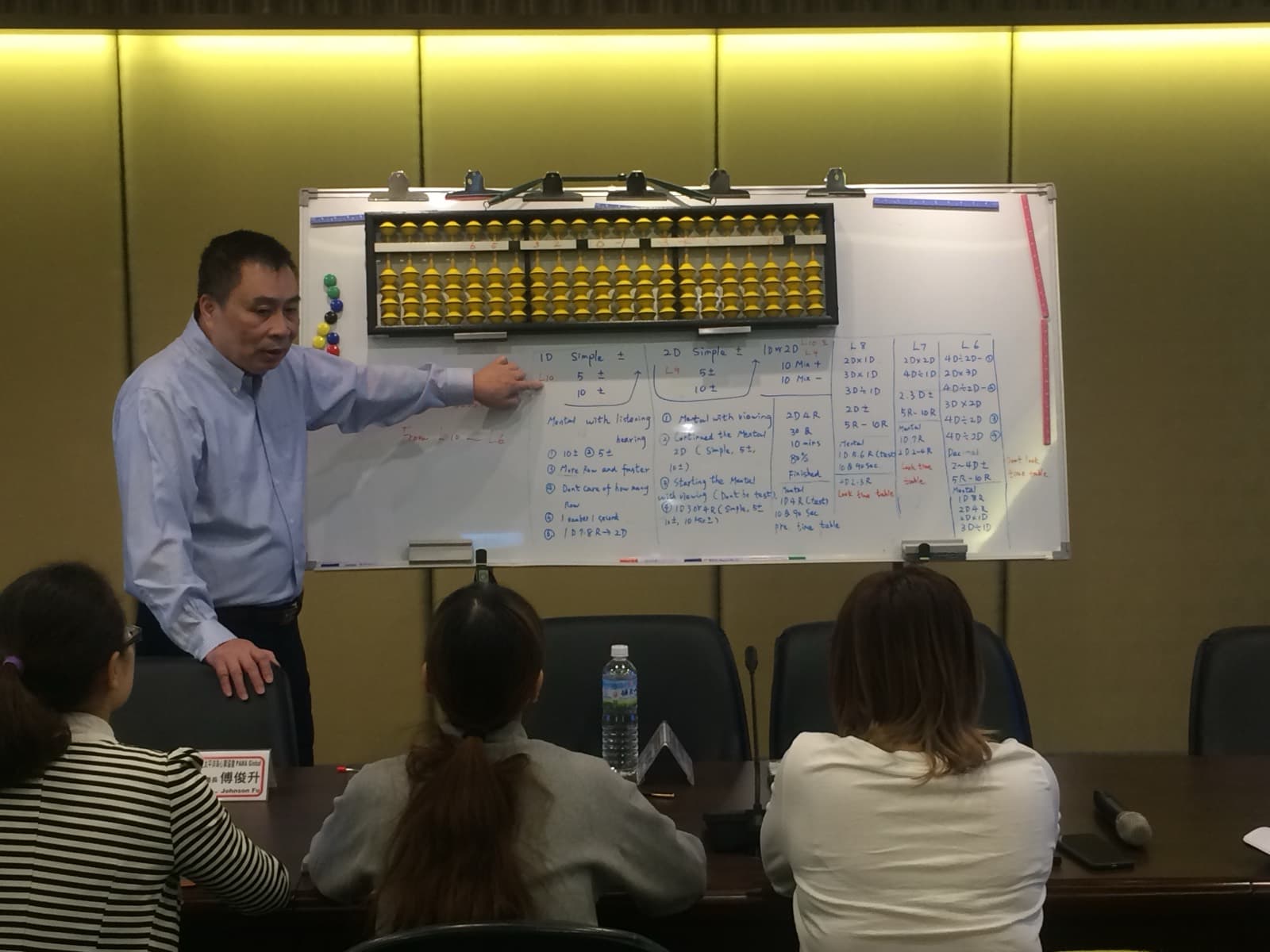An instructor demonstrating on a large classroom abacus